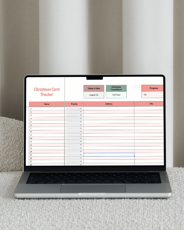 Open laptop displaying a 'Christmas Card Tracker' spreadsheet on screen with columns for Name, Priority, Address, and City.
